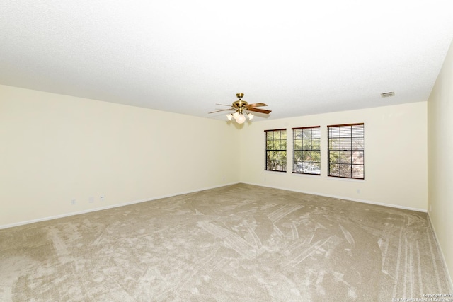 carpeted empty room featuring a textured ceiling and ceiling fan