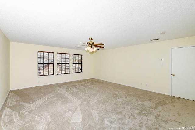 carpeted empty room featuring ceiling fan and a textured ceiling