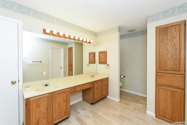 bathroom featuring vanity, hardwood / wood-style floors, and toilet