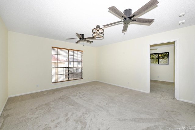 spare room with light carpet, a textured ceiling, and a healthy amount of sunlight