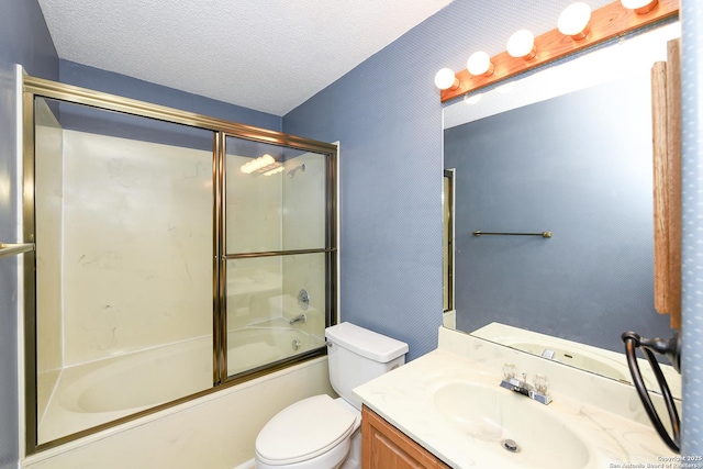 full bathroom with bath / shower combo with glass door, vanity, a textured ceiling, and toilet