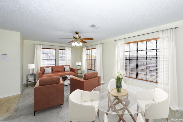 living room with ceiling fan and a textured ceiling