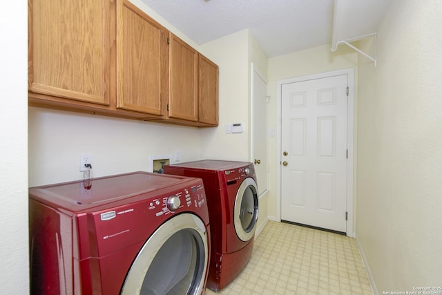 laundry area featuring washing machine and dryer and cabinets