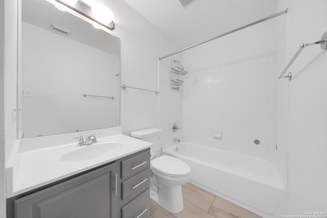 full bathroom with vanity, tiled shower / bath, and toilet