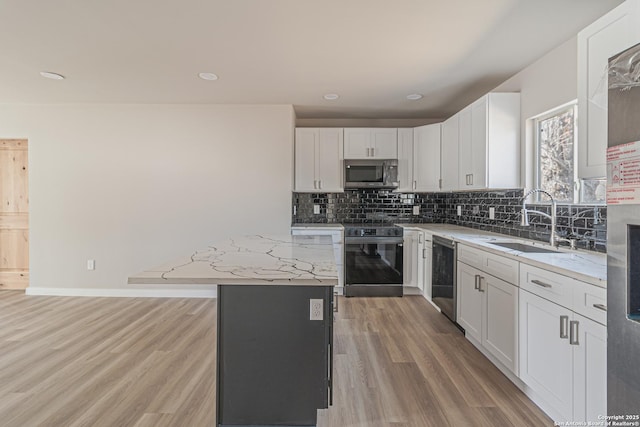 kitchen with white cabinetry, sink, a center island, black range with electric stovetop, and light stone countertops