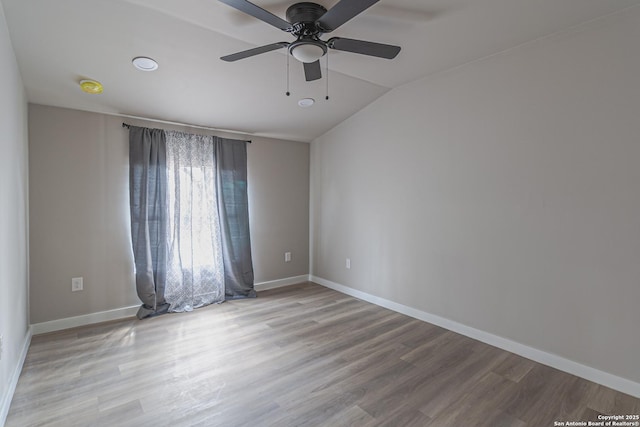 unfurnished room with ceiling fan, lofted ceiling, and light wood-type flooring