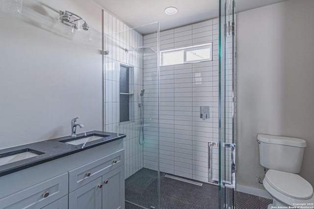 bathroom featuring vanity, a shower with door, and toilet