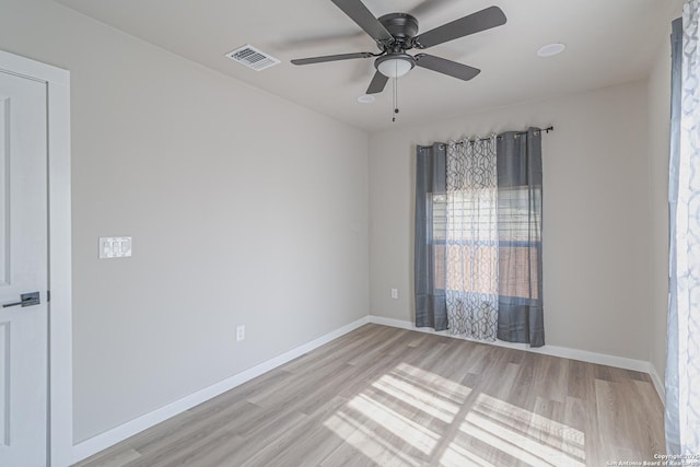 empty room with ceiling fan and light hardwood / wood-style flooring