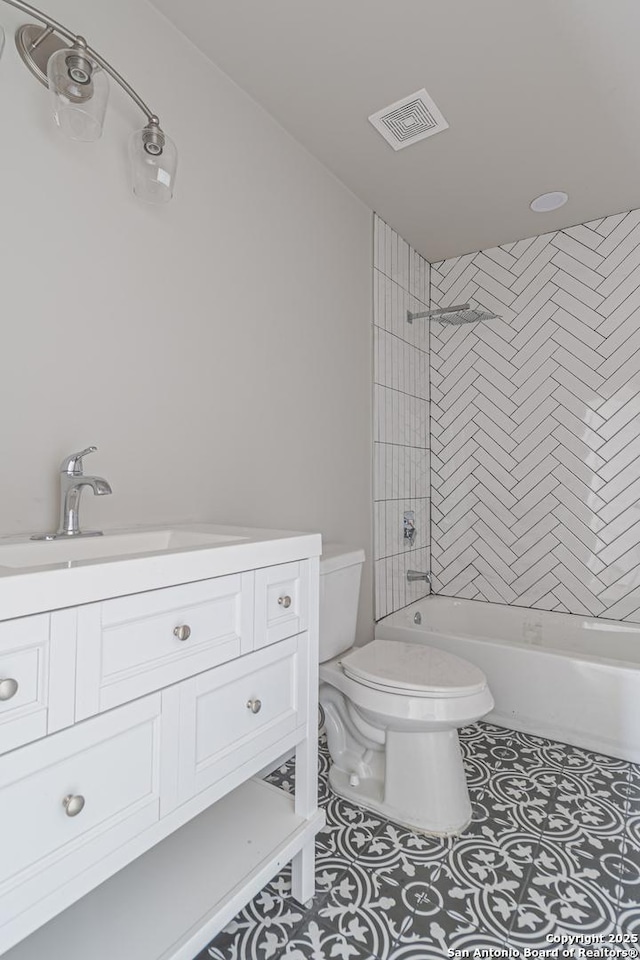 full bathroom featuring tiled shower / bath, vanity, toilet, and tile patterned flooring