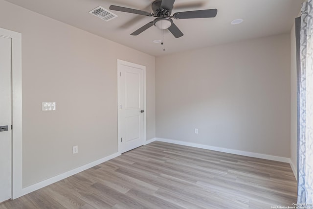 empty room with ceiling fan and light hardwood / wood-style flooring