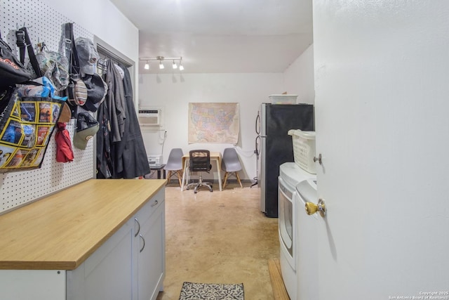 interior space featuring an AC wall unit and washer and clothes dryer