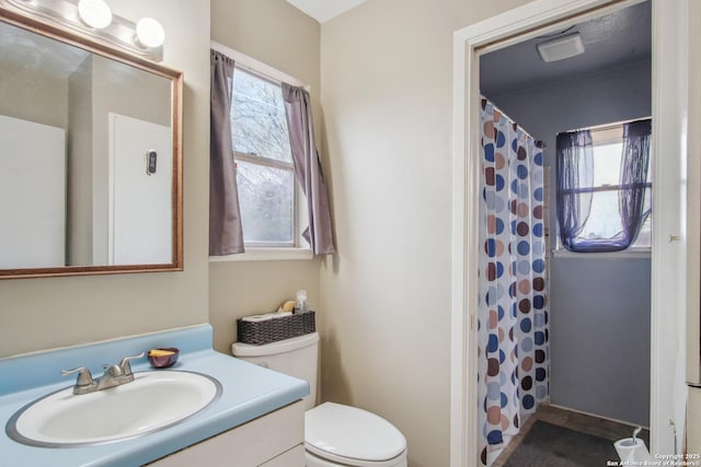 bathroom with vanity, walk in shower, and toilet