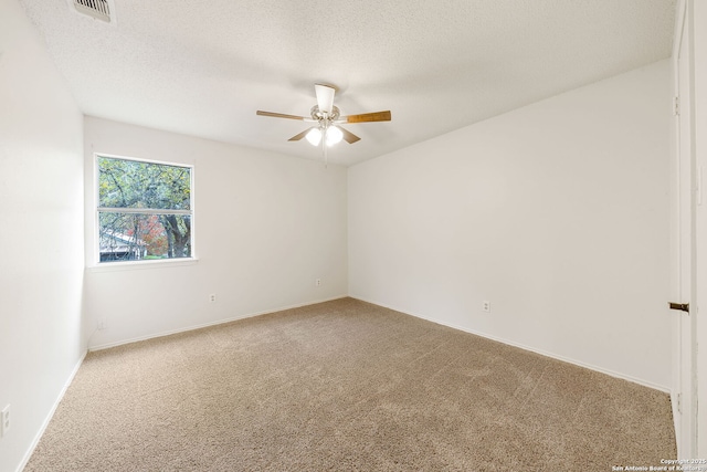 spare room with ceiling fan, a textured ceiling, and carpet