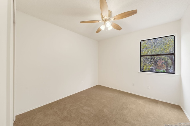 spare room featuring carpet and ceiling fan