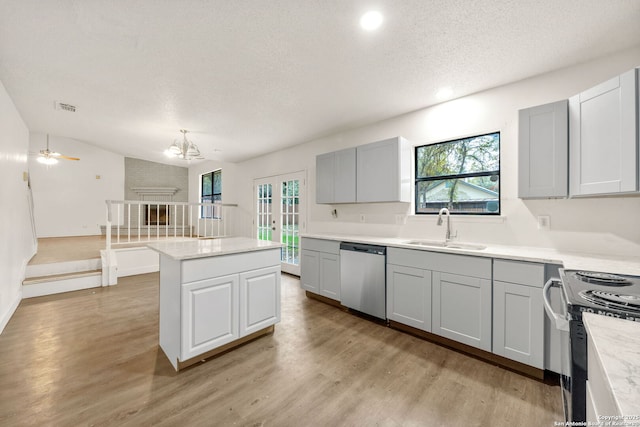 kitchen with gray cabinets, sink, a center island, stainless steel dishwasher, and light wood-type flooring