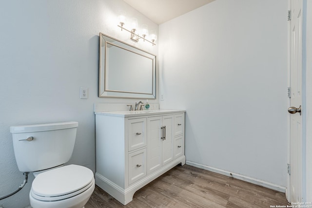 bathroom featuring vanity, hardwood / wood-style floors, and toilet