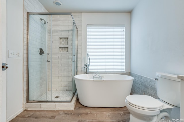 bathroom featuring tile walls, hardwood / wood-style flooring, plenty of natural light, and toilet