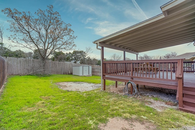 view of yard featuring a wooden deck and a storage unit