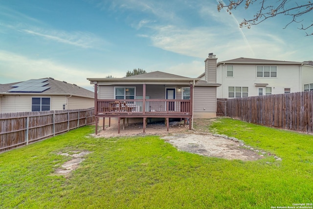 back of house featuring a wooden deck and a yard