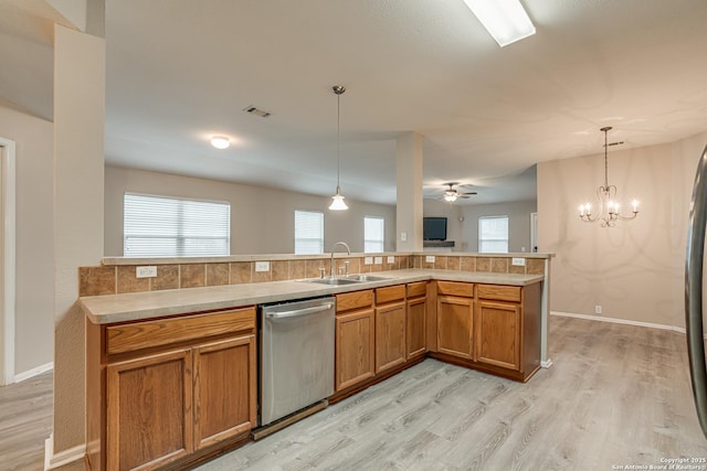 kitchen with dishwasher, sink, hanging light fixtures, and a wealth of natural light