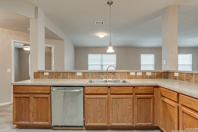 kitchen featuring sink, stainless steel dishwasher, hanging light fixtures, and a healthy amount of sunlight