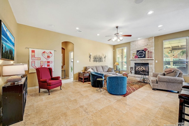 9014 Woodland Pass, Boerne, TX 78006 - living room featuring arched walkways, ceiling fan, a stone fireplace, and a wealth of natural light