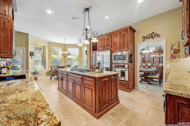 9014 Woodland Pass, Boerne, TX 78006 - kitchen with visible vents, appliances with stainless steel finishes, a sink, light stone counters, and an inviting chandelier