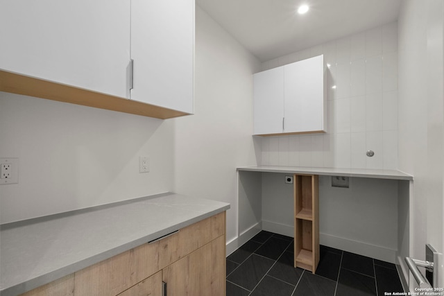 washroom with cabinets and dark tile patterned flooring