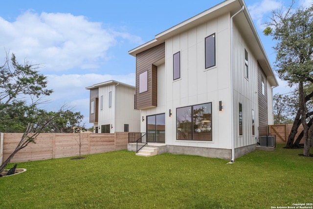 back of property with a yard and central air condition unit