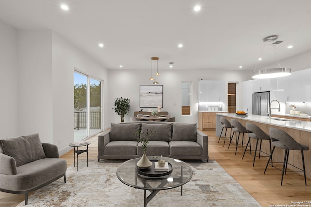 living room with sink and light wood-type flooring