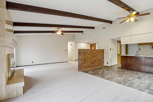 unfurnished living room featuring lofted ceiling with beams, light colored carpet, and ceiling fan