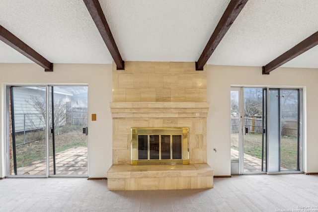 unfurnished living room with a large fireplace, carpet floors, and a textured ceiling