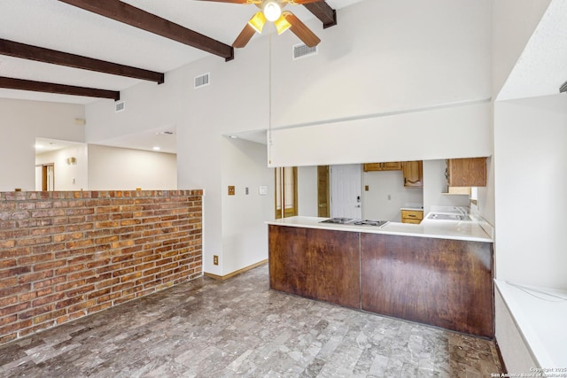 kitchen with sink, ceiling fan, gas stovetop, kitchen peninsula, and beamed ceiling