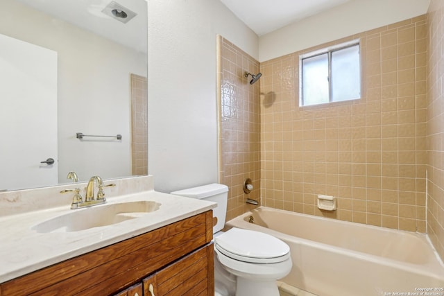 full bathroom with vanity, tiled shower / bath combo, and toilet