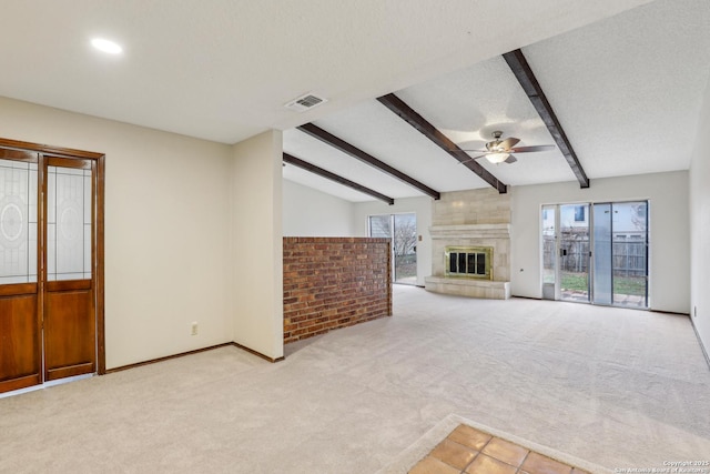 unfurnished living room featuring ceiling fan, a large fireplace, light carpet, and a textured ceiling