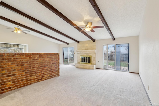 unfurnished living room with ceiling fan, light colored carpet, a textured ceiling, and vaulted ceiling with beams