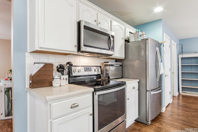 kitchen with white cabinetry, appliances with stainless steel finishes, dark hardwood / wood-style floors, and decorative backsplash