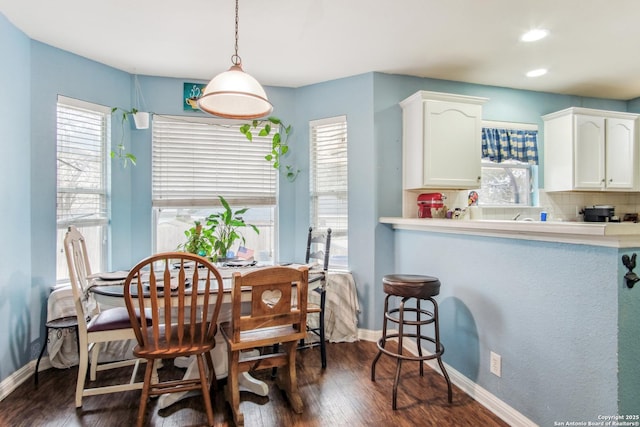 dining area featuring plenty of natural light and dark hardwood / wood-style floors