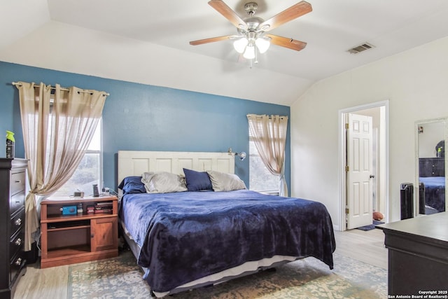 bedroom featuring ceiling fan, light hardwood / wood-style floors, and vaulted ceiling