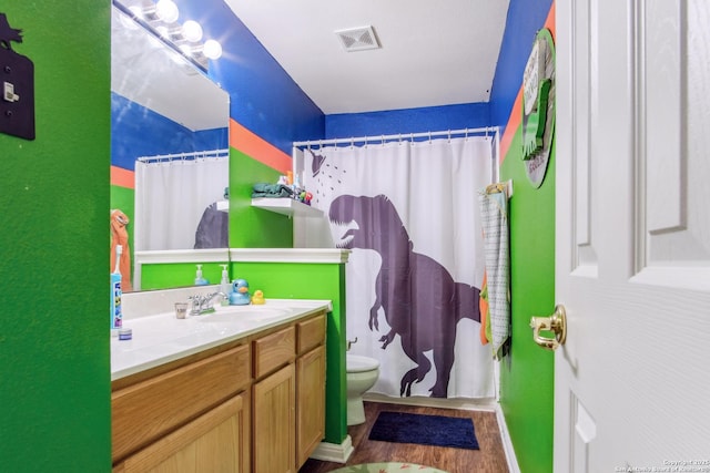 bathroom with hardwood / wood-style flooring, vanity, toilet, and a shower with shower curtain