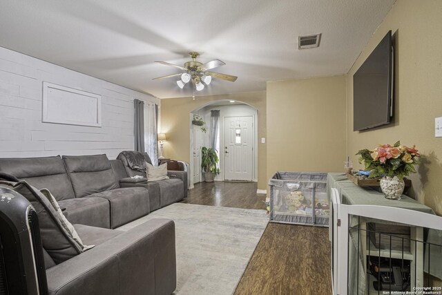 living room featuring ceiling fan and dark hardwood / wood-style flooring