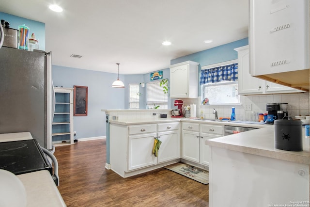 kitchen featuring white cabinets, dark hardwood / wood-style flooring, backsplash, hanging light fixtures, and stainless steel appliances