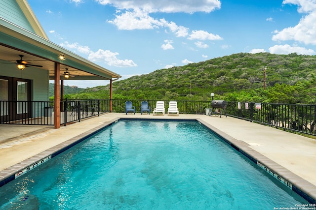 view of swimming pool with a patio, a mountain view, area for grilling, and ceiling fan