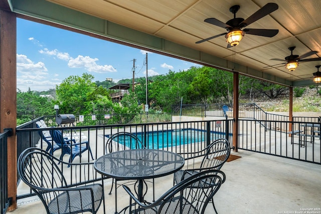 view of patio / terrace with a fenced in pool and ceiling fan