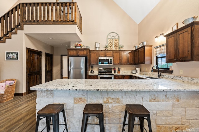 kitchen with sink, a breakfast bar, kitchen peninsula, and appliances with stainless steel finishes