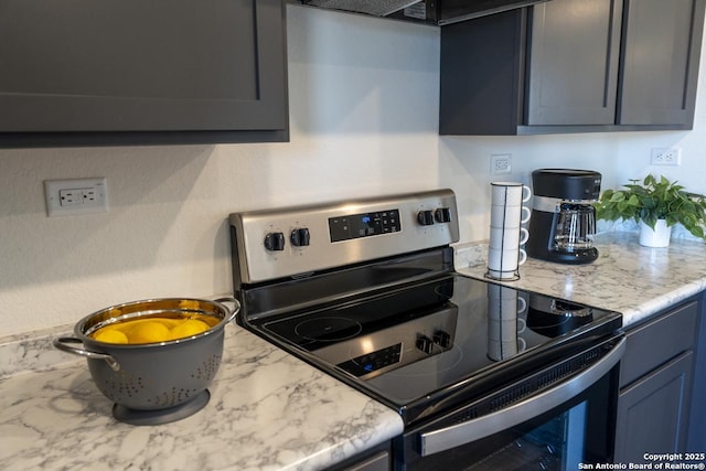 kitchen with stainless steel electric range oven and light stone counters