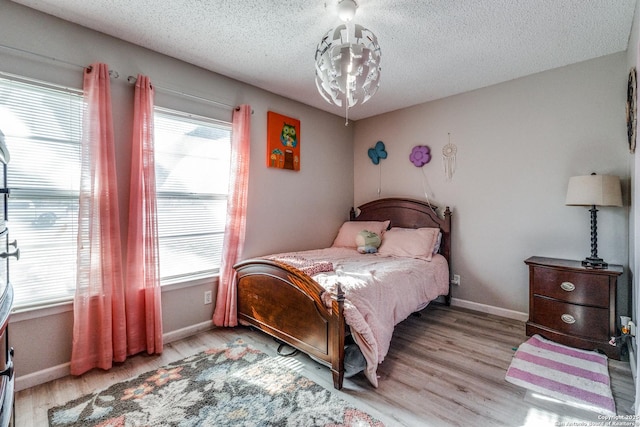 bedroom featuring a textured ceiling and light hardwood / wood-style floors