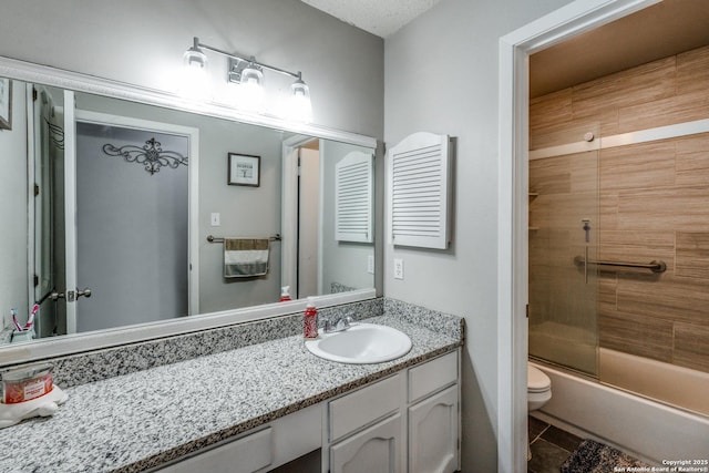 full bathroom featuring bath / shower combo with glass door, vanity, tile patterned floors, and toilet