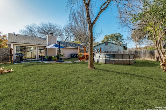 view of yard with a fenced in pool