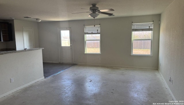 spare room featuring ceiling fan, concrete floors, and a textured ceiling